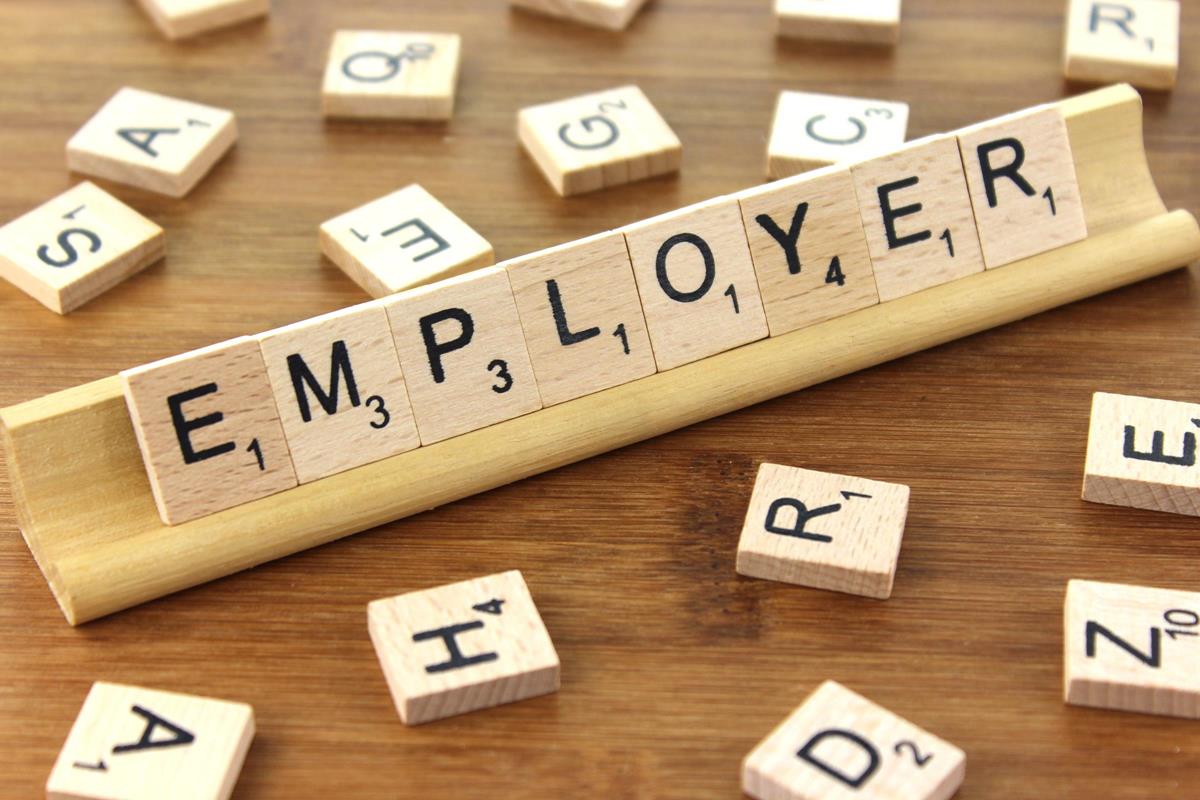 Wood letter tiles spelling employer on a desk