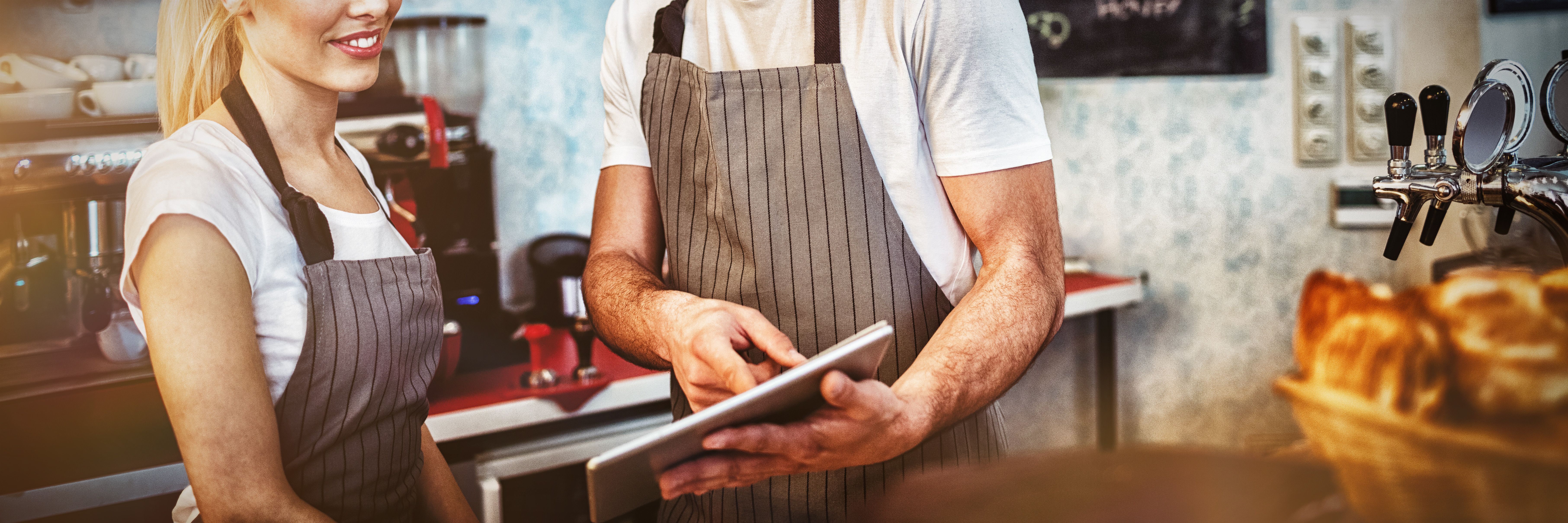 Two cafe employees reviewing information on a tablet